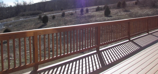 Cedar Siding Custom Home deck with bright sun