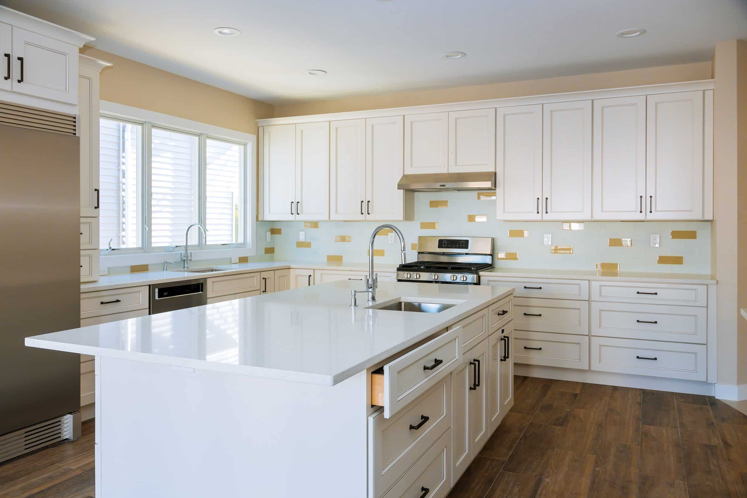 Installing cabinets and counter top in a white kitchen partially installed furniture.