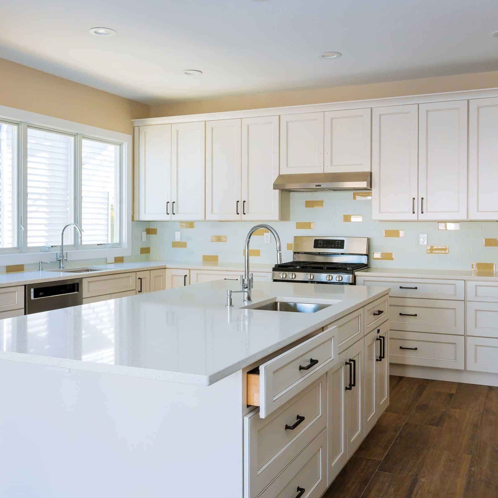 Installing cabinets and counter top in a white kitchen partially installed furniture.